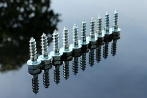 Ten screws lined up on a car hood 