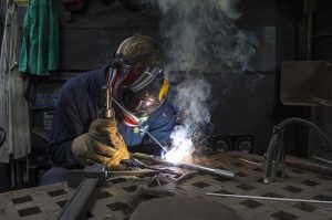 Worker welding a metal workpiece